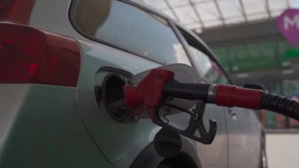 Bijtanken van moderne auto bij benzinestation close-up. Tanken voor auto 's. Pomp gas brandstof bij benzinestation voor spuitmond tank. Handvat van tankpistool. Plaats rode pistool in de tank van de auto voor het bijtanken — Stockvideo