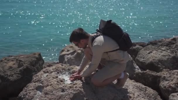 Controleren en onderzoeken van monsters van zeezout dat verdampt is op hete steen uit de Middellandse Zee op Cyprus. Geoloog onderzoekt monsters van kristallen van zeezout. Geologie en wetenschap — Stockvideo