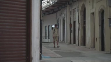 Boş cadde kenti, kapalı dükkanlar, ulusal tecrit sırasında Kıbrıs 'ta paphos pazarı yok. Coronavirüs salgını sırasında iflas. Maskeli turist eski kasabadaki kapalı pazarda yürüyor.