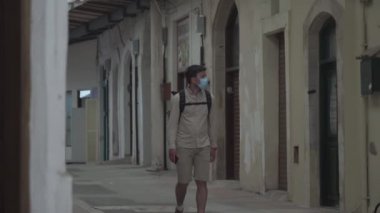 Coronavirus salgını sırasında ana pazar, turist yok, Kıbrıs 'ta Paphos kentinde kilit altında. Maskeli bir turist markette yürür ve kapalı çarşılara bakar. Küçük işletme iflası