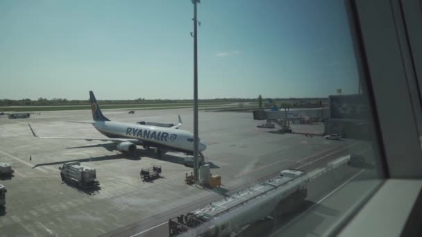 Ucrania, Kiev. Aeropuerto de Boryspil Mayo 8, 2021. Avión Ryanair en la pista del aeropuerto de Boryspil, Ucrania vista a través de la ventana de la terminal cerca de la zona de embarque. Ryanair Airlines compañía aérea de bajo coste — Vídeos de Stock