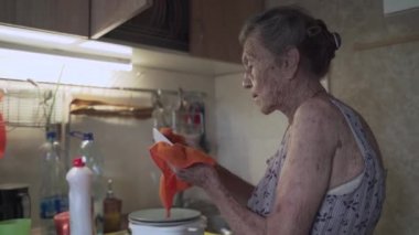 Yalnız, üzgün, yaşlı bir kadın. 90 yaşında, kır saçlı. Eski bir mutfaktaki yoksulluk yüzünden elleriyle bulaşık yıkamak zorunda kalmış. İşteki büyükannem. Eski kirli ev, kötü yaşam koşulları