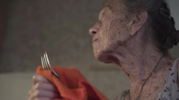 Одинокая грустная пожилая женщина 90 лет с седыми волосами, вынужденная мыть посуду руками из-за бедности дома на старой кухне. Бабушка на работе. Старый грязный дом, плохие условия жизни — стоковое видео