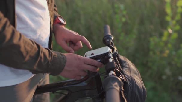 自転車のコンピューターナビゲーター。現代の技術。グローバルな位置決めシステムを備えた自転車ハンドルバー。旅行中にサイクリストチェックサイクリングコンピュータ。GPS装置の経路計画とオフライン地図の表示 — ストック動画