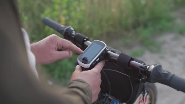 Cyclist use bicycle computer on handlebars of mountain bike in nature. Traveler on cycle looks at map, builds route using GPS on bicycle navigator. Activity tracker and offline maps for bike rides — Stock Video