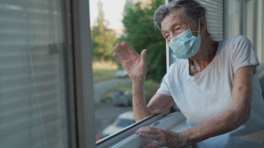 Maskeli yalnız yaşlı kadın pencerenin kenarında duruyor ve hastanede onu ziyarete gelen ailesine el sallıyor. 90 yaşında, kılık değiştirmiş bir kadın huzurevindeki akrabalarına veda ediyor..