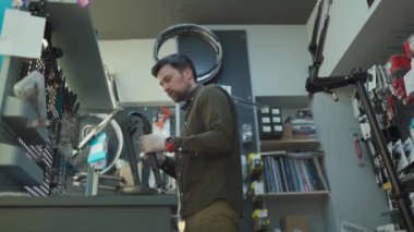 Bisiklet tamirhanesinde teknik uzmanlık. Çekici tamirci kendi atölyesinde müşteri bisikletini tamir ediyor. Teknisyen çalışma odasında bisiklet süspansiyon çatalını tamir ediyor. Bisiklet dükkanı, bisiklet servisi.