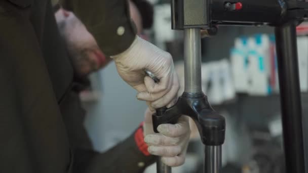 Mecânico de bicicleta no trabalho na oficina de fixação de garfo de bicicleta. Reparador reparando amortecedor dianteiro para esporte de bicicleta de montanha, suspensão de bicicleta MTB na loja velocipede. Serviço de bicicleta. Montagem de bicicletas — Vídeo de Stock