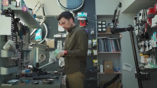 Homme réparateur fixation fourche de vélo dans l'atelier de réparation et d'entretien de vélo. Mécanicien de bicyclette réparer l'amortisseur avant du cycle. Thème de la profession. Les techniciens réparent la partie bicyclette — Video