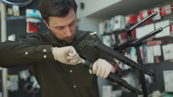 Expertise technique prise en charge magasin de vélos. Mécanicien attrayant fixe vélo clients à son propre atelier. Technicien fixe fourche de suspension de vélo dans la salle de travail. Magasin de vélos, service de vélos — Video