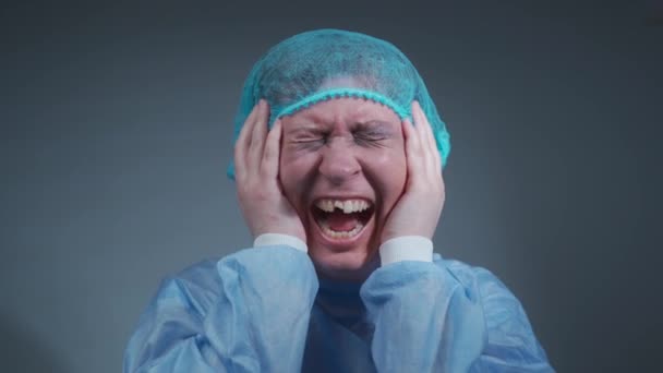 Porträt einer Patientin im Krankenhaus in medizinischer Kleidung nach einem Autounfall erhielt Gesichtsverletzungen und Zähne, Blick auf die Kamera auf grauem Hintergrund. Weinende weibliche Opfer häuslicher Gewalt und Missbrauch — Stockvideo