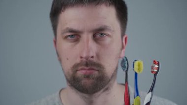 Yeni bir diş fırçası alma zamanı geldiğinde, beyaz adam eskimiş diş fırçasını onaylamıyor. Diş fırçasını değiştirmenin önemi, ağız hijyeni. Diş bakımı. Veda etmek için sadık eski diş fırçam