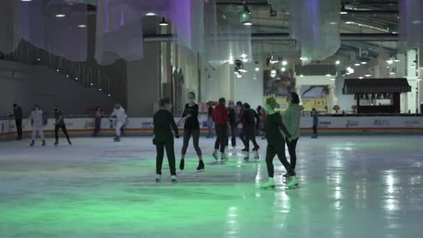 Oekraïne, Kiev 20 december 2020 schaatsbaan in winkelcentrum droomstad. Groep mensen met maskers schaatsen op een overdekte ijsbaan tijdens covid quarantaine. Veel gemaskerde bezoekers op de ijsbaan bij het coronavirus — Stockvideo