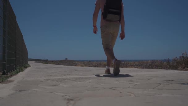 Passeggiata costiera lungo il Mar Mediterraneo sull'isola di Cipro nella città di paphos. Viaggiatore con zaino cammina lungo sentiero vicino al lungomare. Persone attive. Viaggiare, escursioni e stile di vita attivo — Video Stock