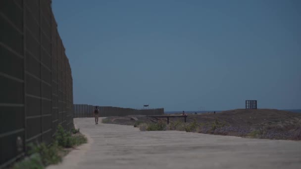 Paseo costero a lo largo del mar Mediterráneo en la isla de cyprus en la ciudad de paphos. Viajero con mochila camina a lo largo de sendero cerca de paseo marítimo. Gente activa. Viajar, senderismo y estilo de vida activo — Vídeo de stock