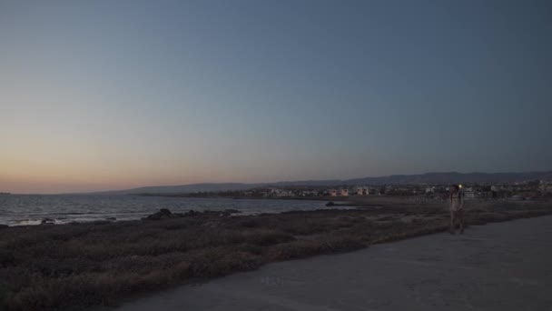 Paseo costero a lo largo del mar Mediterráneo en la isla de cyprus en la ciudad de paphos. Viajero con mochila camina a lo largo de sendero cerca de paseo marítimo. Gente activa. Viajar, senderismo y estilo de vida activo — Vídeos de Stock