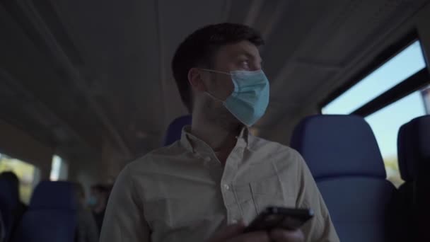 Muž dojíždějící v metru během pandemie. Muž cestující v maskovací masce během uzamykání covid-19 pomocí telefonu uvnitř vlaku. Koncepce prevence infekcí a znečištění ovzduší — Stock video