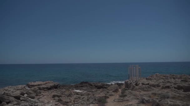 Monumento de arte blanco cerca del mar Mediterráneo en rocas en la ciudad de Pafos en Chipre. Famosa atracción turística sendero de la calzada costera que rodea el parque arqueológico y parte del museo Paphos Chipre — Vídeos de Stock