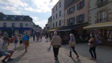 Fransa 'nın Brittany bölgesindeki restoranları ve dükkanlarıyla eski Concarneau kasabasında yürüyen insanlar. Fransa, Bretagne Concarneau 31 Ağustos 2021. Fransız surlu ortaçağ kasabası Concarneau