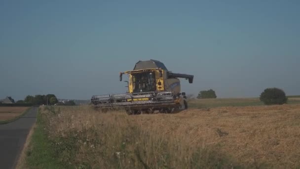 New Holland Agricoltura giallo combinare i raccolti di grano in Francia Bratny regione agosto 25, 2021. Cesoie di grano. Combina sul campo. Personale industriale su un tema agricolo in Europa — Video Stock