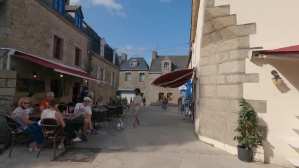 As pessoas relaxam em restaurantes de rua e cafés na antiga cidade murada de Concarneau, na França, região da Bretanha, no verão 31 de agosto de 2021. Uma cena de rua dentro das muralhas da cidade de Concarneau com lojas de alimentos — Vídeo de Stock