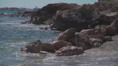 Yaz mevsiminde, Kıbrıs Rum Kesimi açıklarında, Paphos kenti yakınlarında, Akdeniz 'in kayalık kıyıları ve dalgaları. Akdeniz yakınlarında ıslak taşlar var. Kayalık sahil kıyısı ile şaşırtıcı deniz manzarası