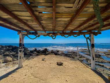 Kıbrıs 'ta deniz sörfü, Akdeniz' in mavi dalgaları. Rocky plajı taşladı. Yaz günü. Güneşli cennet. Güneşli gündüz deniz manzarası. Kıbrıs plajını seyret. Akdeniz yakınlarındaki taşlar.