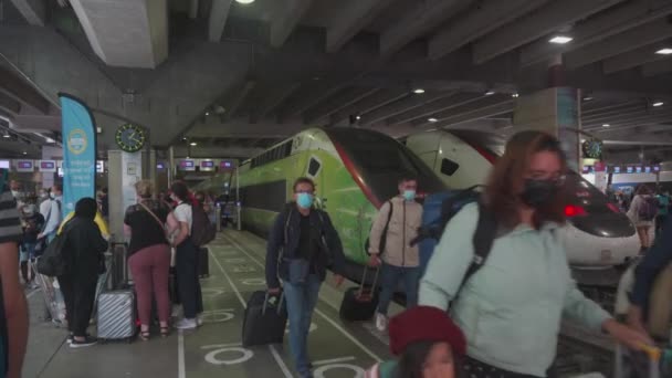 Франція, Париж, 21 серпня 2021 року. Люди в захисних масках на центральній залізничній станції Gare du Nord під час коронавірусного періоду ходять по поїзду TGV. Пасажири проходять через Gare du Nord на платформі. — стокове відео