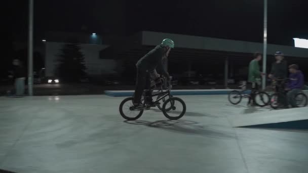 Ukraina, Kijów, 18 września 2021. Miejski Park. Nastoletni skateboardziści, rowerzyści bmx, sportowe skutery trenują, wykonują sztuczki, wieczorem skaczą po skateparku miejskim. Zdrowy styl życia, sporty ekstremalne, redakcja — Wideo stockowe