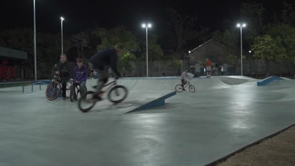 Oekraïne, Kiev, 18 september 2021. Stadspark. Tieners skateboarders, bmx fietsers, sportscooters trainen, doen trucs, springen in de stad skatepark in de avond. Gezonde levensstijl, extreme sporten, redactionele artikelen — Stockvideo