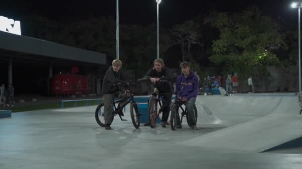 Ουκρανία, Κίεβο, 18 Σεπτεμβρίου 2021. Αστικό πάρκο. Έφηβοι skateboarders, bmx ποδηλάτες, σπορ σκούτερ τρένο, κάνουν κόλπα, άλμα στην πόλη skatepark το βράδυ. Υγιεινός τρόπος ζωής, extreme sports, σύνταξη — Αρχείο Βίντεο