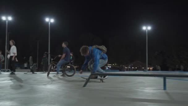 Ukraine, Kiew, 18. September 2021. Stadtpark. Jugendliche Skateboarder, BMX-Radfahrer, Sportroller trainieren, machen Tricks, springen abends im städtischen Skatepark. Gesunder Lebensstil, Extremsport, Leitartikel — Stockvideo