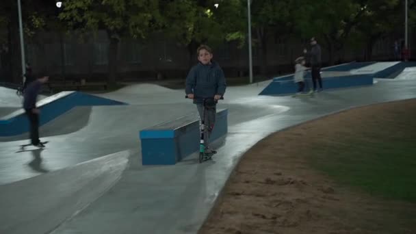 Ucrania, Kiev, 18 de septiembre de 2021. Parque Urbano. Skateboarders, ciclistas bmx y niños en scooters deportivos hacen trucos en el parque de skate de la ciudad por la noche. Deportes extremos, amistad, juventud, concepto de estilo de vida — Vídeos de Stock