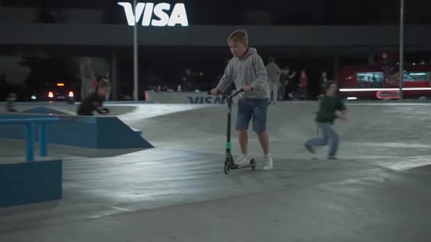 Ucrania, Kiev, 18 de septiembre de 2021. Parque Urbano. Los patinadores adolescentes, los ciclistas bmx, los scooters deportivos entrenan, hacen trucos, saltan al parque de skate de la ciudad por la noche. Estilo de vida saludable, deportes extremos, editorial — Vídeos de Stock