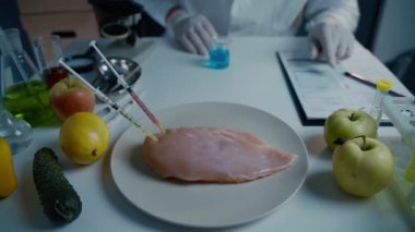 Taze sebzeler, meyveler, masada et ve laboratuvarda kalite kontrolüne devam eden bilim adamı. Genetik mühendisliği laboratuvarı. GDO gıda konsepti. Taze ete enjekte edilmiş. Genetik mühendisliği