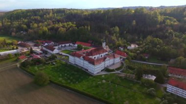 Yukarı Bavyera 'daki Schaeftlarn Abbey ve Praelatengarten parkının insansız hava aracı görüntüleri. Bahçe tasarımı, kırsal alan, yemyeşil tarlalar ve mavi gökyüzü altında kültürel mirası olan tarihi Benedikt manastırı. 