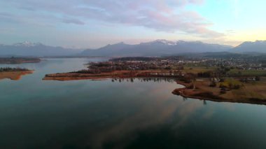 Chiemsee Gölü, Bavyera, Almanya 'da Rosenheim ve Prien am Chiemsee yakınlarında yer alır. Günbatımında hava ilkbahar manzarası, Bayerisches Meer olarak bilinen Chiemgau bölgesinin güzelliğini gözler önüne seriyor. Alpenvorland