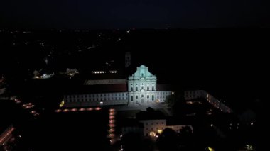 Fuerstenfeldbruck, Bayern 'deki Naechtliche Luftaufnahme des Klosters Fuerstenfeld. Barocke Klosterkirche St. Maria ist eindrucksvoll beleuchtet, aufgenommen bei Daemmerung aus der Vogelperspective. 