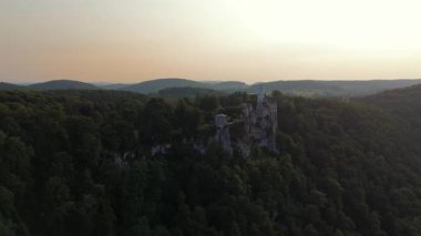 Schloss Lichtenstein in der Abendsonne, aufgenommen mit Drohne. Das 19. Jahrhundert-Schloss thront spektakulaer ueber dem Albtrauf nahe Reutlingen, Deutschland mit Blick auf Wald und Tal. 