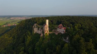 Honau 'nun yukarısındaki Swabian Alpleri' nde Lichtenstein Kalesi 'nde insansız hava aracı keşfi. Alacakaranlıkta destansı manzara ve Alman mirası titreşimleriyle yakalandı. Schloss Lichtenstein Wuerttemberg Luftbild. 
