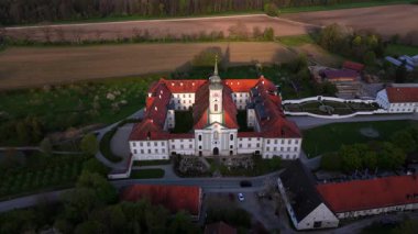 Luftaufnahme des Klosters Schaeftlarn und des barocken Praelatengartens in Oberbayern. Benediktinerabtei tarihsel park, eingebettet in gruene Landschaft dava lich von Muenchen, Deutschland. 