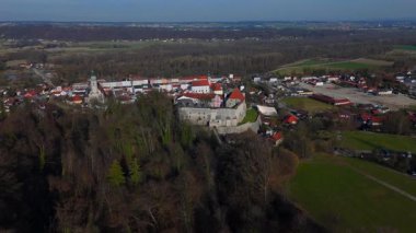 Burg Tittmoning, St. Laurentius Kilisesi ve Tittmoning, Bavyera, Almanya 'da ortaçağ şehir duvarına sahip tarihi şehir manzarası. Mavi gökyüzü ve yeşil tarlaları olan bahar manzarası.