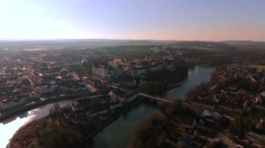 Neuburg Kalesi 'nin ve Almanya' nın Bavyera bölgesinin tarihi Neuburg an der Donau 'nun insansız hava aracı görüntüsü. Tuna Nehri ve şehir silueti güneşli bir Aralık sahnesinde berrak gökyüzünün altında beliriyor..