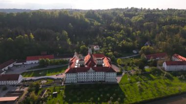 Kloster Schaeftlarn ve tarihi Praelatengarten parkının tepeden aşağı manzarası. Güney Almanya 'da Barok mimarisi, çiçek açan doğa ve panoramik insansız hava aracı perspektifi ile manzara manastırı kompleksi.