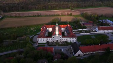 Almanya 'nın Bavyera kentindeki Kloster Schaeftlarn ve Praelatengarten parklarının hava manzarası. Barok Benedictine Manastırı ve baharda etrafı çayırlarla ve Münih 'in güneyindeki Isar Vadisi ile çevrili peyzaj parkı..