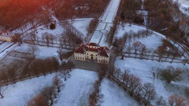 Almanya, Münih yakınlarındaki Schleissheim Sarayı 'nın yukarısında insansız hava aracı videosu. Karlı kış manzarası, donmuş kanallar ve Wittelsbach kraliyet malikanesinin tarihi barok mimarisi..