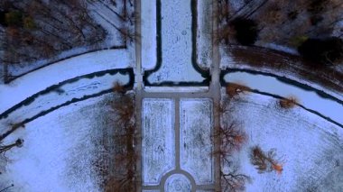 Oberschleissheim, Bavyera, Almanya 'daki Schleissheim Sarayı' nın insansız hava aracı panoraması. Kış manzarası karla kaplı bahçeler ve dramatik turuncu günbatımı gökyüzünde parlayan barok saraylar..