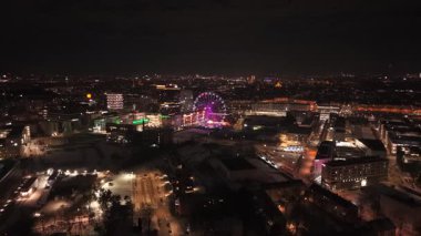 Münih 'in doğusunda gece drone görüntüleri Werksviertel bölgesini ve Umadum dönme dolabını gösteriyor. 31 Aralık 'ta Münih Ost tren istasyonu yakınlarındaki aydınlık şehir manzarasının hava manzarası