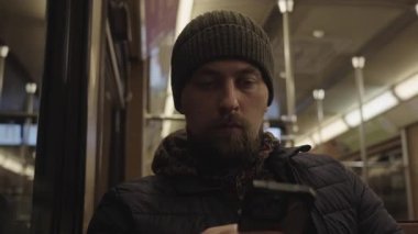 Muenchen 'deki klasik bir Baureihe A metrosunun özgün iç mekanı. Erkek yolcu oturuyor ve akıllı telefonunda kablosuz bağlantı kullanıyor. Batı Avrupa 'da nostaljik kentsel geçiş.