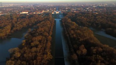 Aralık gün batımında Münih 'te Schloss Nymphenburg' un hava aracı videosu, Neuhausen-Nymphenburg parkında uzun Nymphenburg Kanalı, barok sarayı simetrisi ve yumuşak kış renklerini gösteriyor.
